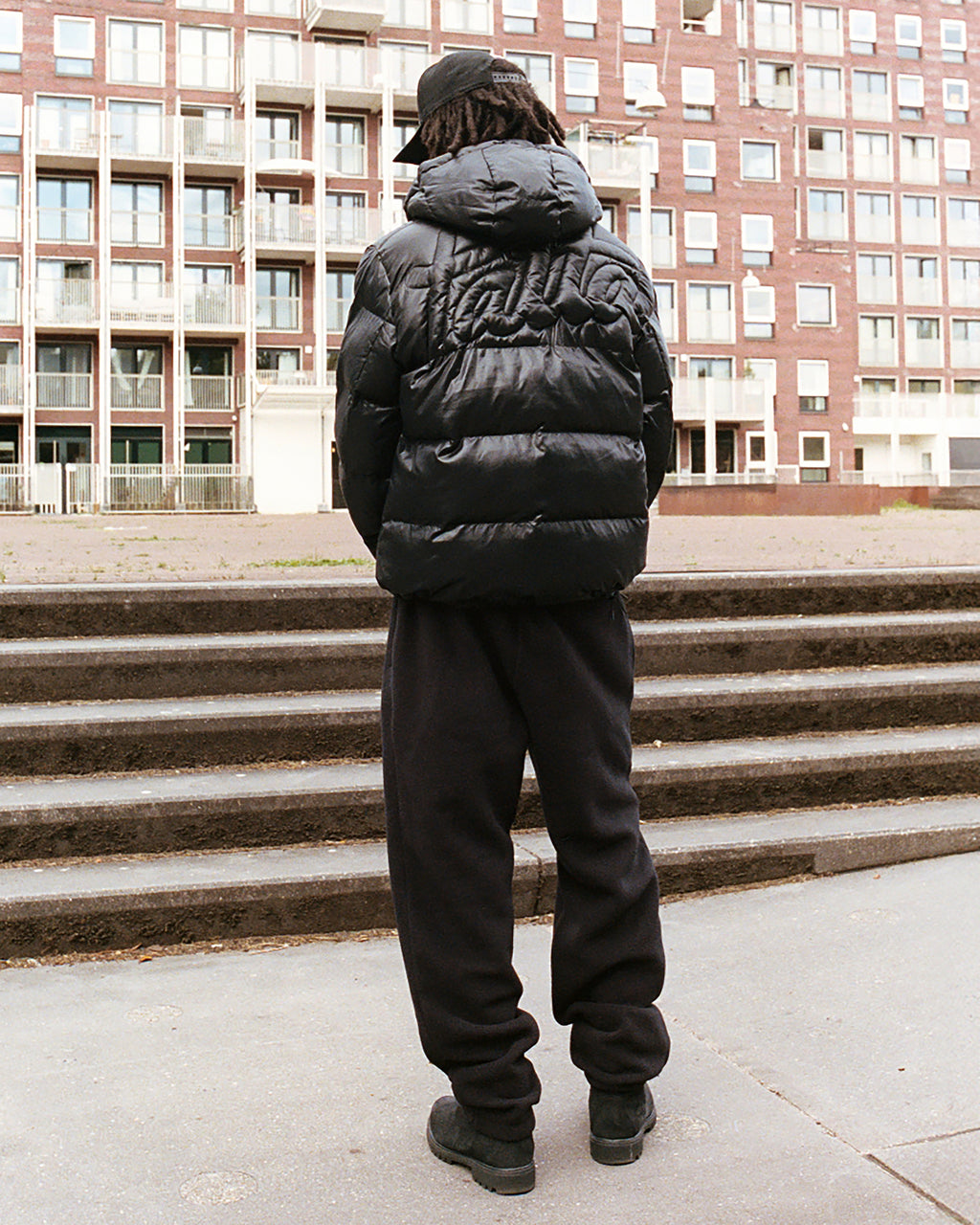 Foto van iemand met een zwarte puffer jas aan